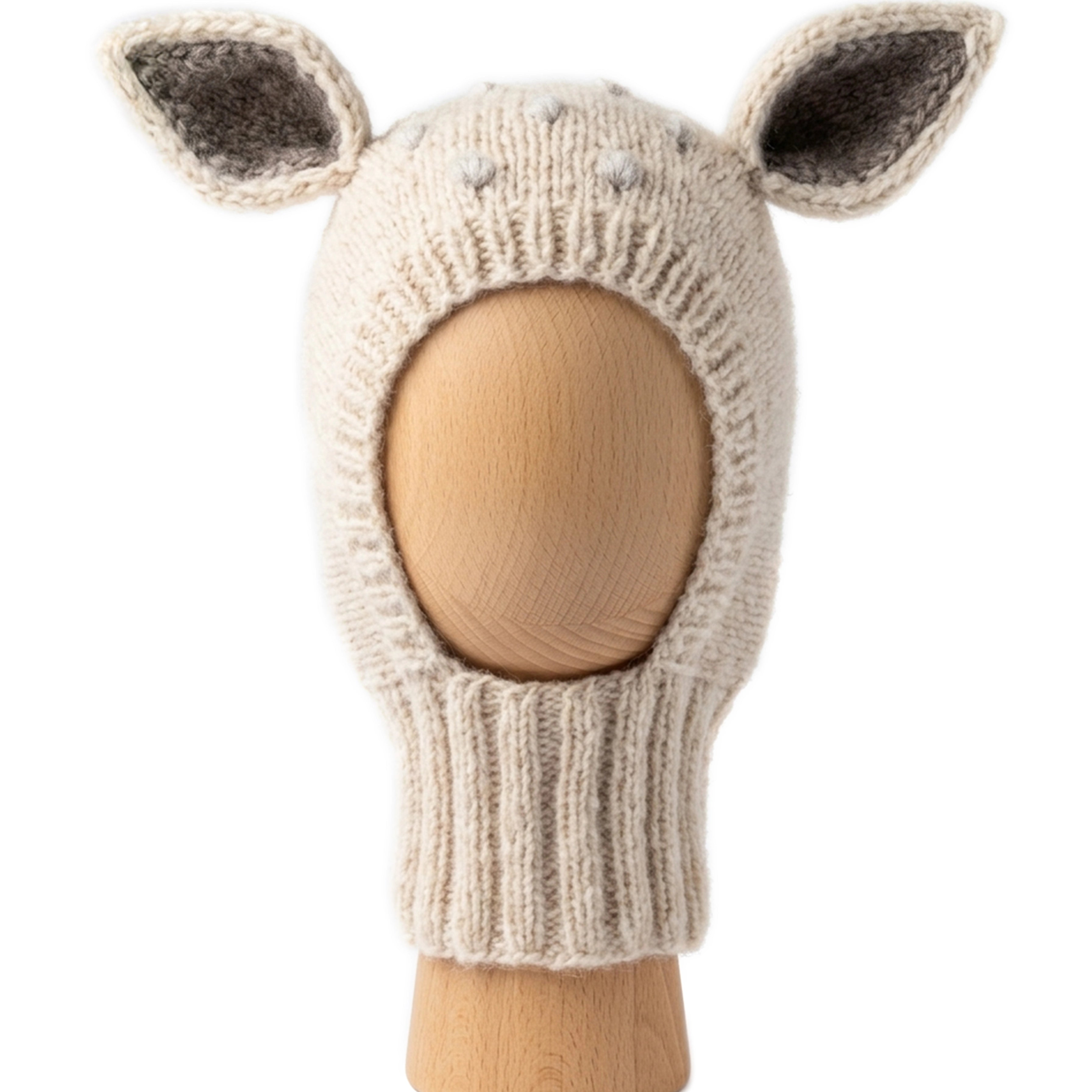 Bambi Balaclava, a knitted balaclava for kids with ears, shown in wheat with pearl grey spots on a wooden display head.