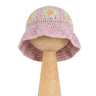 Kapelusz Daisy Wild Berry Sorbet – pastelowo-fioletowy szydełkowy kapelusz dziecięcy z wzorami stokrotek na drewnianej podstawce | Hand-crocheted pastel purple baby sun hat with mint and peach daisy flowers on a wooden stand