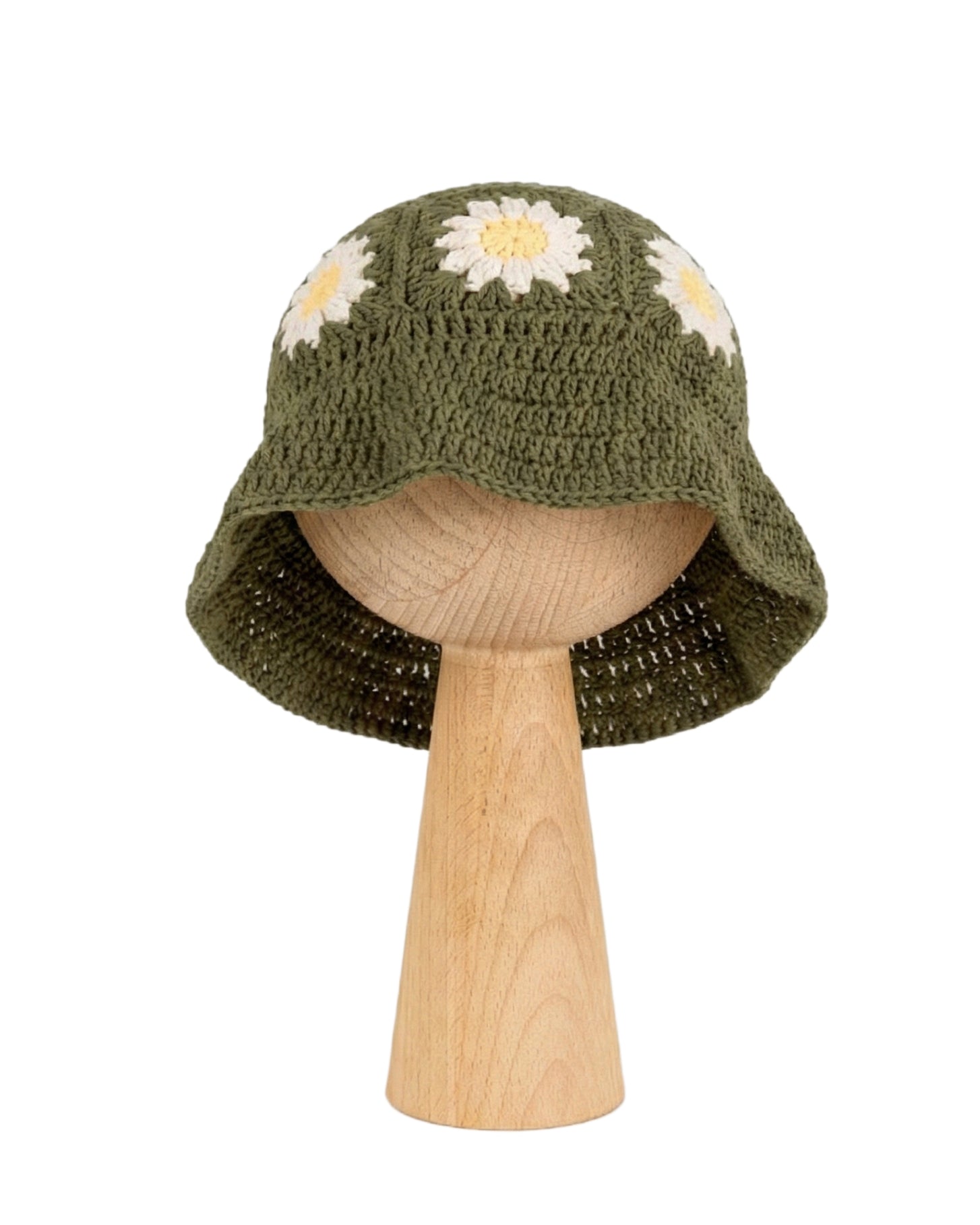 Ręcznie szydełkowany zielony kapelusz dziecięcy ze stokrotkami na drewnianej podstawce | Hand-crocheted earthy green baby sun hat with white and peach daisy flowers on a wooden stand