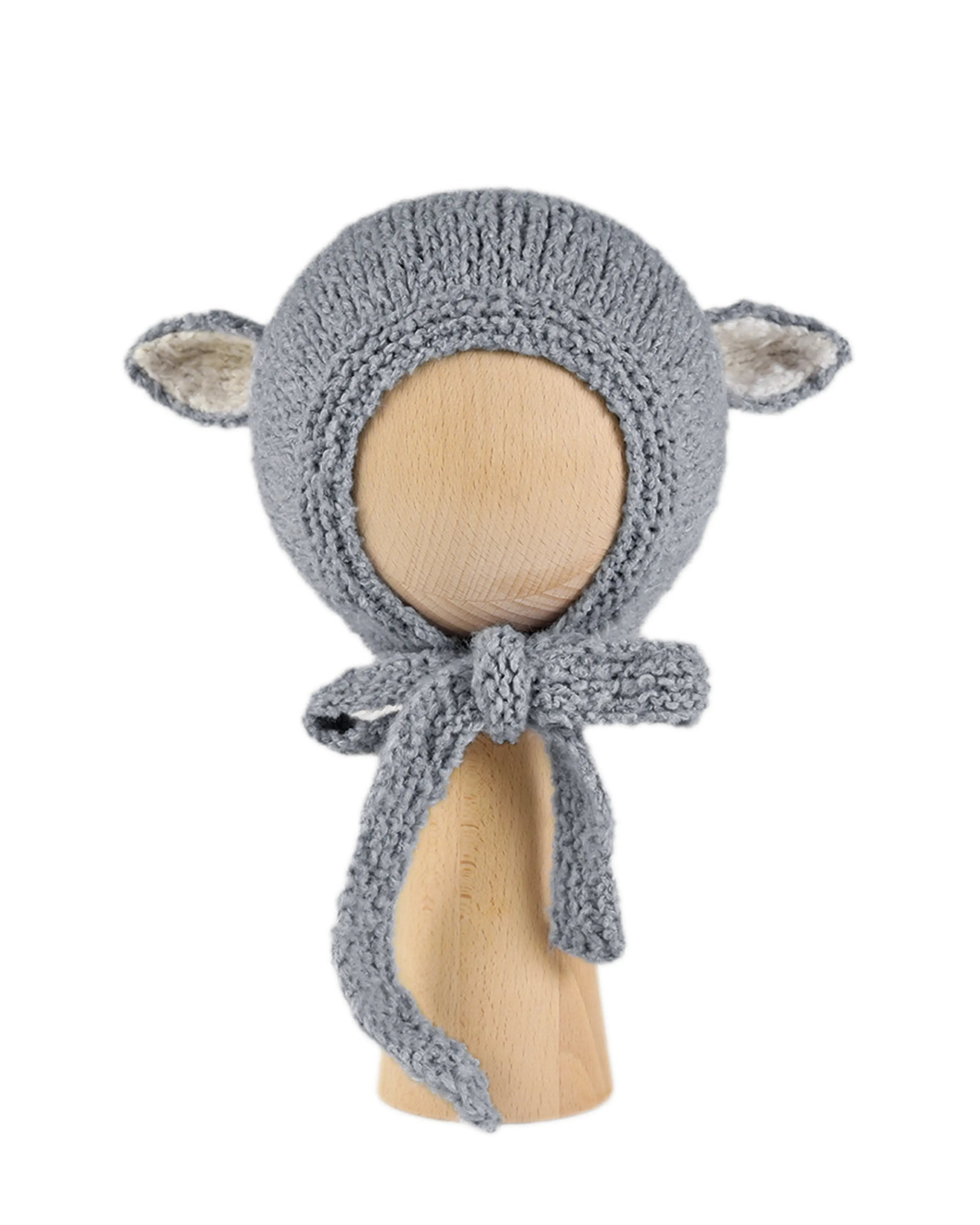 Sheep Bonnet in Charcoal, a knitted cotton bonnet with ecru-lined ears and knitted ties, shown on a wooden display head.